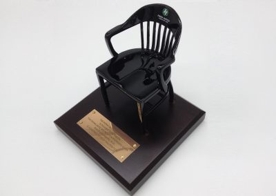 black miniature college chair of Fred Hutchinson Cancer Research Center on brown base with brass plate
