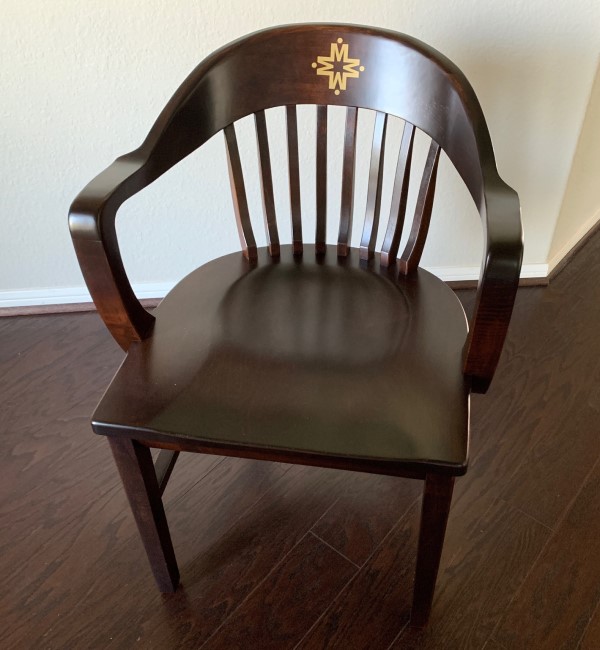 Dark brown classic alumni chair with gold logo, an art deco office chair