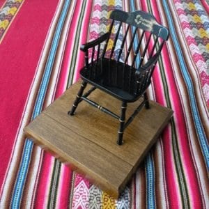one of our black miniature fundraising chairs on a brown base and colorful fabric from Peru 
