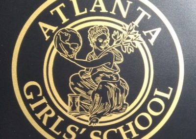 Gold Atlanta Girls' School seal on b;ack chair for Client Testimonials
