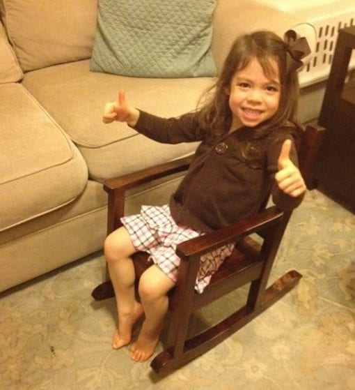 A young girl with thumbs up sitting in a brown Affinity Child Rocking Chair - client testimonials