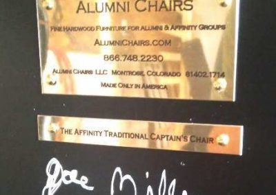 Brass company plate and product plate under a black alumni chair f college chairs