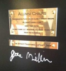 Brass company plate and product plate under a black alumni chair f college chairs
