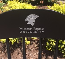 Missouri Baptist University Chair Logo on black chair in garden ACAC Colorado Rod Drake, Logo Chair with silver engraved logo