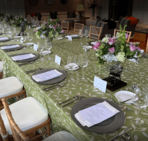 Large table setting at a special event  with two miniature captain's chairs on table